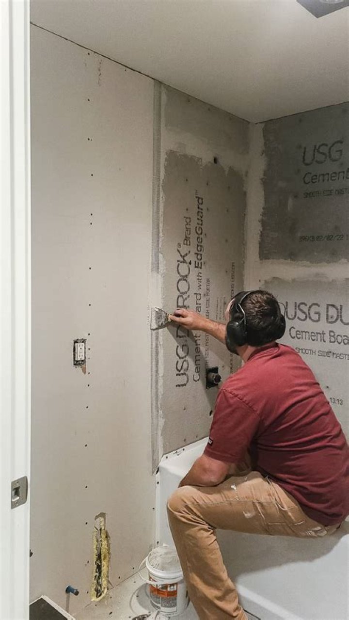 Do you need to tape drywall behind tile?