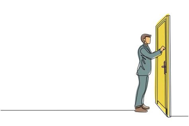 Who is knocking at the door change into passive voice?